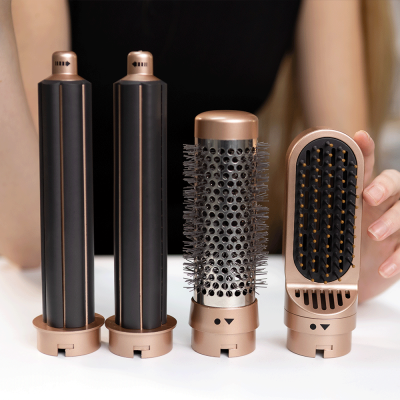 Quatro acessórios para modelador de cabelo de plástico dourado e preto sobre superfície branca