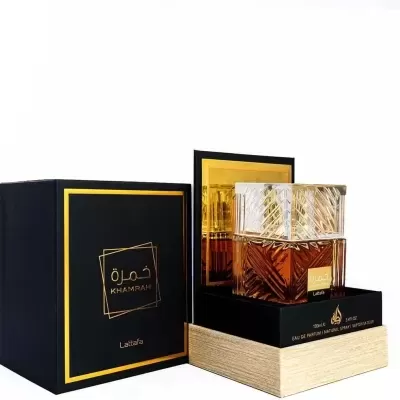 Frasco de perfume âmbar com tampa transparente e caixa preta com texto dourado