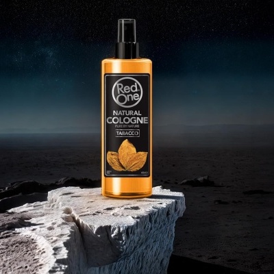 Colónia natural Red One Tabacco em frasco âmbar sobre rocha clara com fundo escuro e céu estrelado