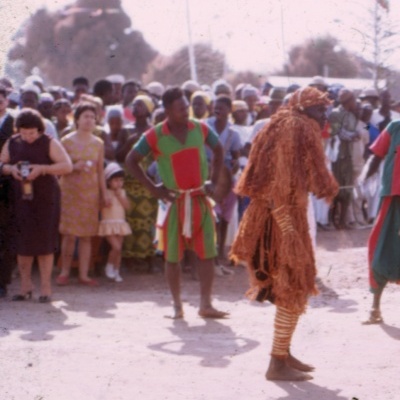 pessoas com roupas tradicionais numa festa ao ar livre com bandeira