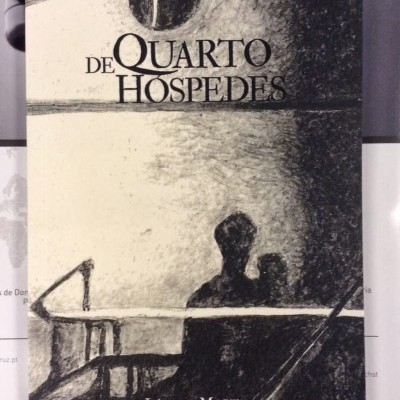 Capa de livro com ilustração em tons de cinza e preto e texto '1 DE QUARTO HÓSPEDES' e 'Língua Morta'.