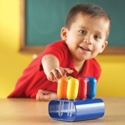 Brinquedo colorido com base azul e botões laranja, amarelo, vermelho e azul