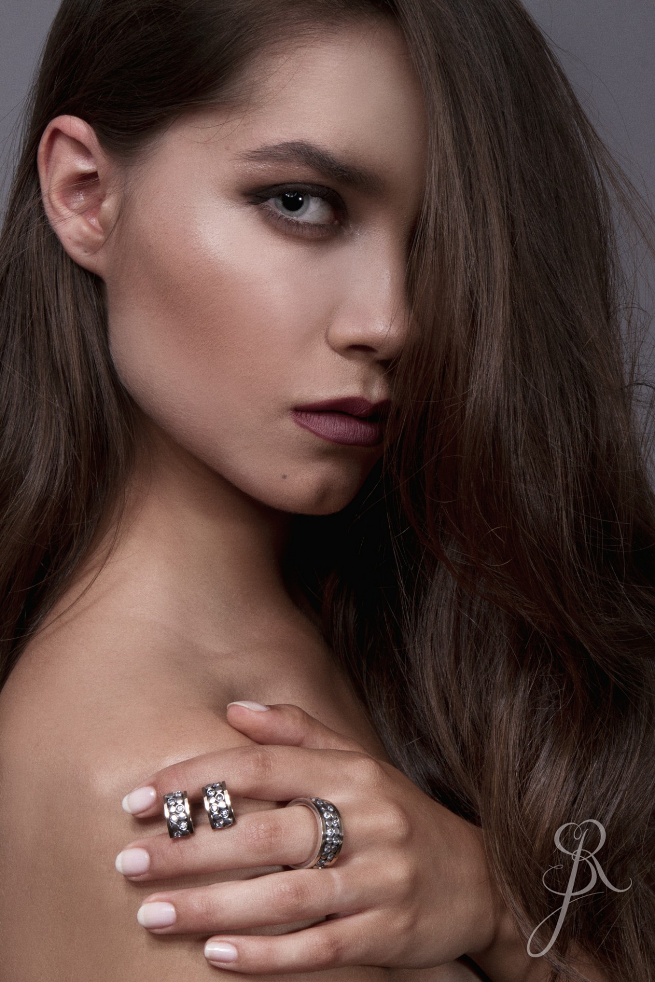 Aliança Rotativa c/Zircónias Mulher com anéis prateados e cabelo castanho longo