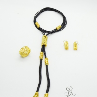 Conjunto de bijuteria com colar preto e dourado, anel dourado e brincos dourados sobre fundo branco