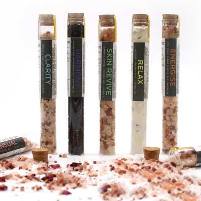 Tubos de sais de banho coloridos com tampas de cortiça e etiquetas de nomes distintos