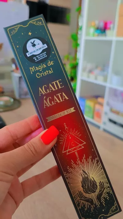 Embalagem retangular do kit Magia de Cristal Agate Ágata com símbolos em dourado e vermelho.