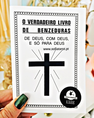 Capa de livro branca com texto preto e cruz preta, selo redondo e mão segurando com unhas verde escuro