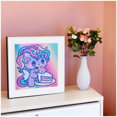 Quadro decorativo com ilustração de unicórnio e vaso com flores num móvel branco
