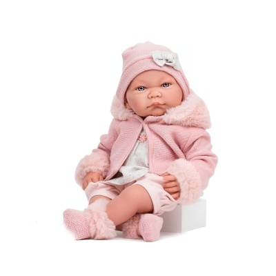Boneca realista vestida de rosa com casaco, gorro e meias felpudas, sentada num cubo branco
