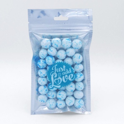 Bolas azuis e brancas em saco plástico transparente com selo azul que diz Just add Love