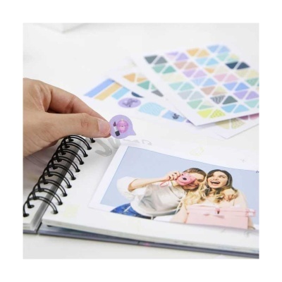 Álbum espiral com fotografia de duas mulheres e autocolante a ser colocado