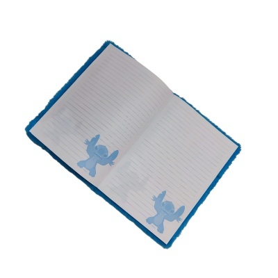 Caderno aberto com capa azul peluda e páginas com linhas e personagem Stitch