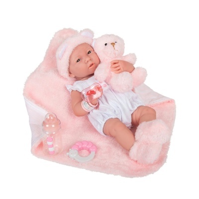 Boneca bebé realista com roupa branca e acessórios rosa, deitada em almofada rosa