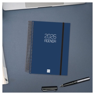 Agenda espiral azul 2026 com elástico e caneta preta sobre superfície azul