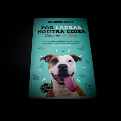 Capa de livro azul-turquesa com foto de cão sorridente e texto em preto e branco
