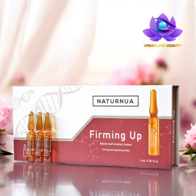 Ampolas de vidro âmbar NATURNUA Firming Up com embalagem branca e rosa sobre superfície refletora e fundo com flores cor-de-rosa