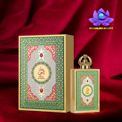 Frasco e caixa de perfume Queen of Arabia com design verde, vermelho e dourado, tampa em forma de coroa sobre tecido vermelho