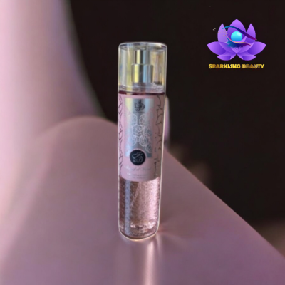 Frasco de spray corporal transparente com líquido rosa e etiqueta floral