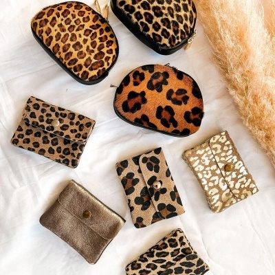 Porta-moedas variados com padrão animal print sobre tecido branco