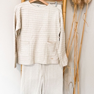 Conjunto creme camisola com bolsos e saia pendurado em estrutura de bambu