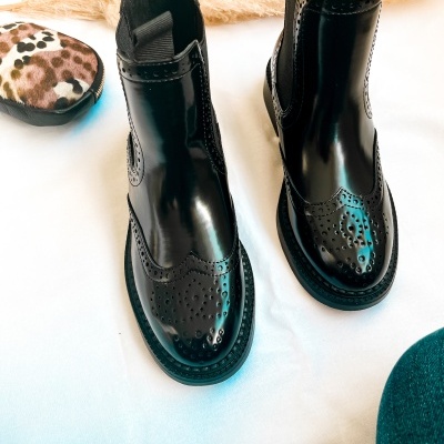 Par de botas pretas de verniz com detalhes perfurados e bolsa estampada de leopardo