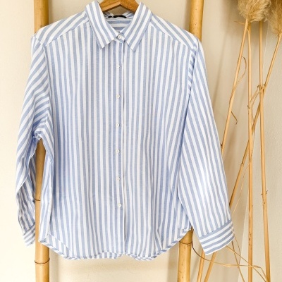 Camisa às riscas azuis e brancas pendurada num escadote de bambu