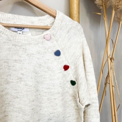 Camisola bege claro em malha com botões de coração coloridos e cabide de madeira