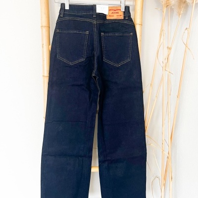 Calças de ganga pretas penduradas num cabide de madeira