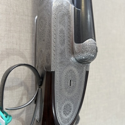 Espingarda de cano duplo com gravações detalhadas e coronha de madeira