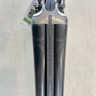 Espingarda de canos duplos com gravações e punho em madeira escura