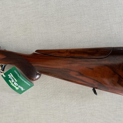 Parte traseira de espingarda em madeira polida com etiqueta verde