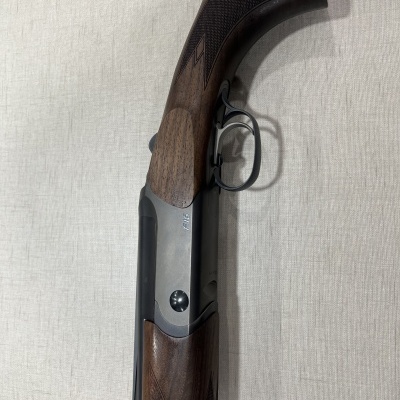 Espingarda de caça com coronha e punho em madeira escura e armação metálica cinza