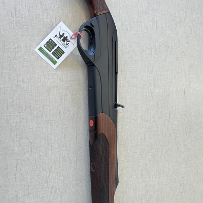 Espingarda com coronha e guarda-mão em madeira castanha e corpo metálico preto sobre fundo cinza