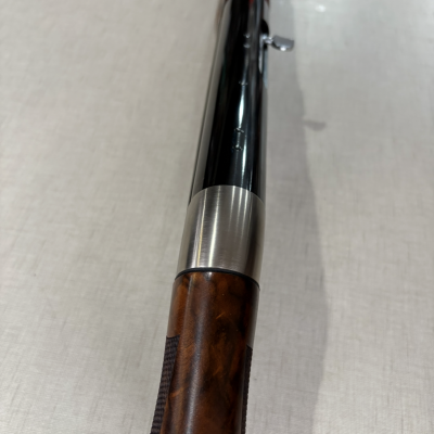 Barbearia com cabo de madeira castanha e lâmina metálica sobre superfície clara