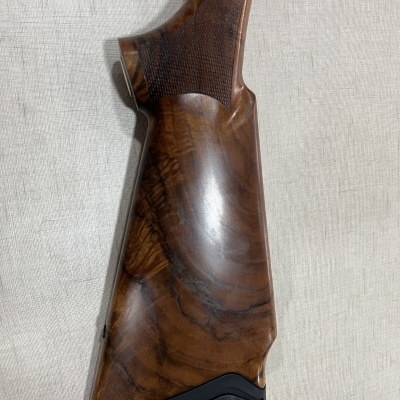 Parte traseira de arma de madeira polida com acolchoamento preto na base