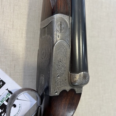 Espingarda de canos duplos com madeira e metal gravado, etiquetas ao lado