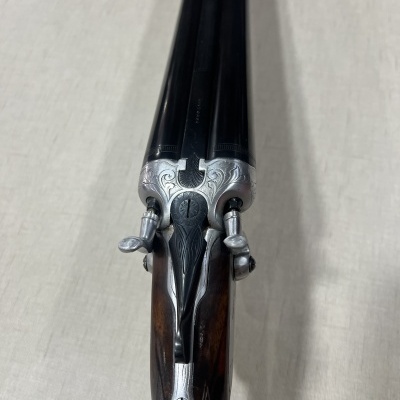 Espingarda de canos duplos vista de cima com detalhes em metal e madeira