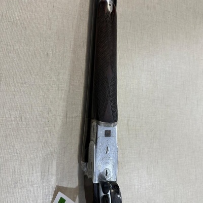 espingarda de canos duplos com gravações decorativas e madeira escura