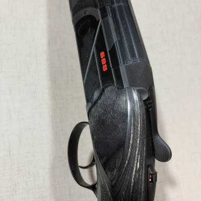 Espingarda de calibre 12 com empunhadura em madeira e número 688 em vermelho.