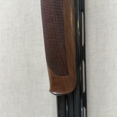 Coronha de madeira castanha texturada e cano metálico preto com furos alongados