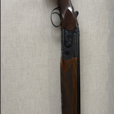 Espingarda de canos duplos com coronha em madeira castanha e metal preto decorado