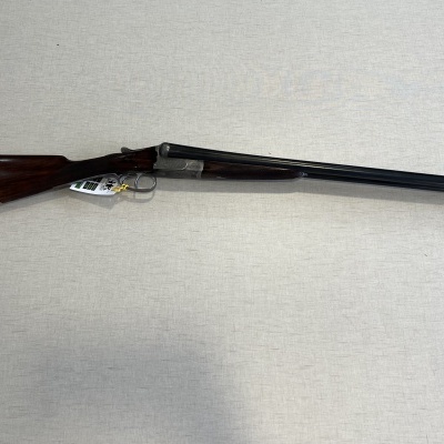 Espingarda de canos duplos com coronha em madeira escura sobre fundo claro