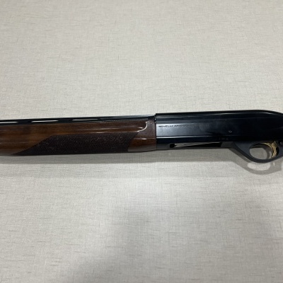 Espingarda com madeira e metal sobre superfície branca