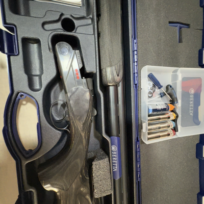 Espingarda Beretta numa mala rígida azul com munições e acessórios