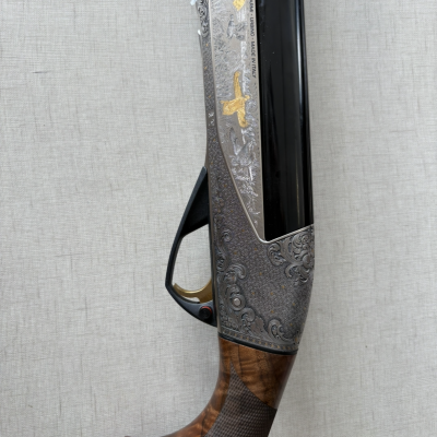 Espingarda com empunhadura em madeira, gravuras metálicas e cano preto