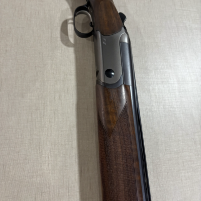 Espingarda de caça com coronha em madeira e estrutura metálica prateada