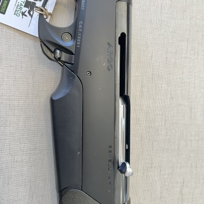 Espingarda Benelli Argo preta com etiquetas e código de barras sobre tecido bege