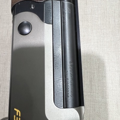 Espingarda metálica e madeira com gravação Blaser Germany no cano.