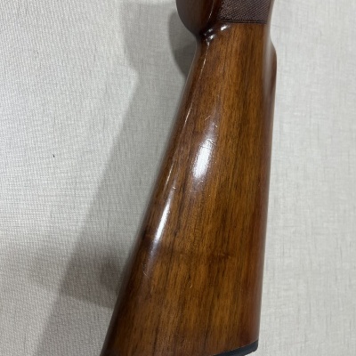 Coronha em madeira polida de arma de fogo castanha com borda preta