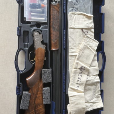 Estojo aberto azul com espingarda e acessórios